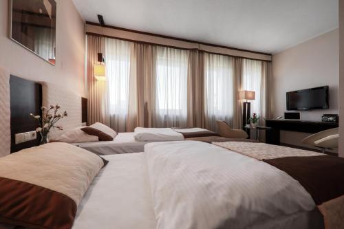 pokój hotelowy z 2 łóżkami i telewizorem w obiekcie Hotel Borowiecki w Łodzi