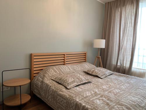 a bedroom with a bed and a table and a window at eleven in Jūrmala