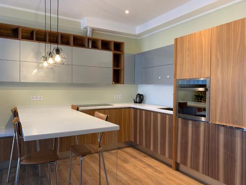 a kitchen with wooden cabinets and a white table and chairs at eleven in Jūrmala