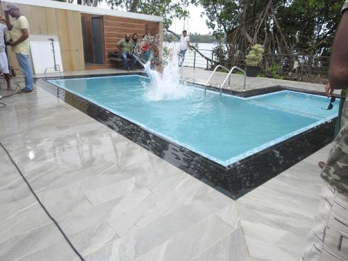 a fountain in a pool with people standing around it at Lago Leisure Resort & Spa in Cherai Beach