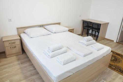 een bed met witte lakens en witte kussens erop bij Гостиница Kokshe Inn in Köksetaw