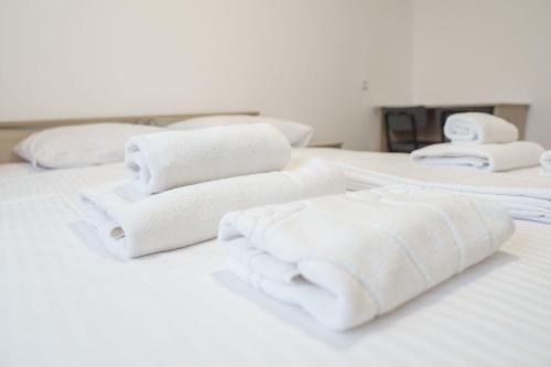 un grupo de toallas blancas sentadas encima de una cama en Гостиница Kokshe Inn, en Kokshetau