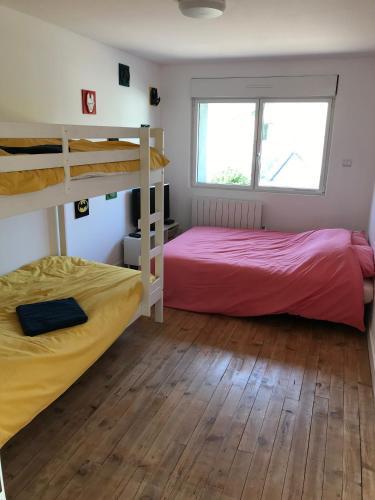 deux lits superposés dans une chambre avec parquet dans l'établissement Gîte Le Coq Au Vert en Suisse Normande, à Hamars