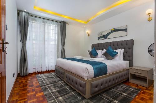 een slaapkamer met een bed en een raam bij Tranquil Residence by Edmor Suites in Nairobi