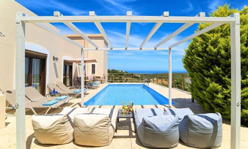 a villa with a swimming pool and a house at Cretan Sunny Villa Heated Pool in Kournás