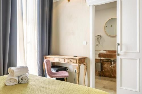 een kamer met een tafel en een bureau met een stoel bij Catedral Suites Jerez in Jerez de la Frontera