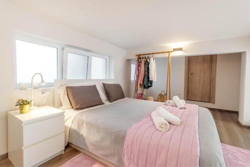 a bedroom with a large bed with a pink blanket at Olea Apartment in Corfu Town