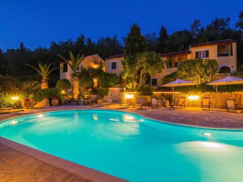 a swimming pool in front of a house at night at Andrikos studio A in (( Kalodhikátika ))