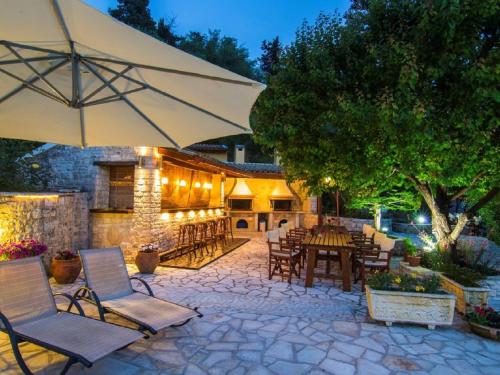 a patio with a table and chairs and an umbrella at Andrikos studio A in (( Kalodhikátika ))