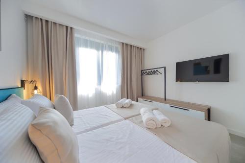 a bedroom with a white bed with towels on it at 9 apartments in Jagodina