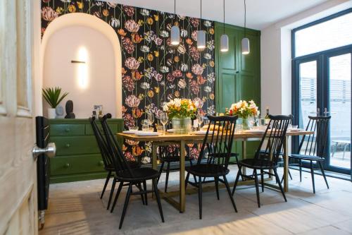 a dining room with a table with chairs and a floral wall at Casa Craven by Casa del Artista, 4 Bedroom Designer Home in Skipton