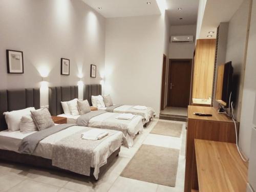 a hotel room with three beds and a flat screen tv at Sea Gull Marina Hotel in El Alamein