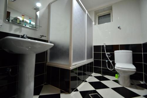 a bathroom with a sink and a toilet at Ofoq Al Raha Hotel Apartment in Taif