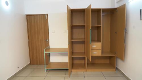 a closet with wooden shelves and a desk at The White Orchid Luxury Service Apartments in Ernakulam