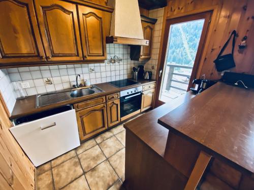 a kitchen with wooden cabinets and a counter top at Chalet Le Jeuna in Morgins