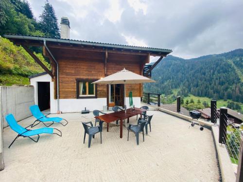 a patio with a table and chairs and an umbrella at Chalet Le Jeuna in Morgins