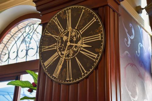 a clock with roman numerals is attached to a wall at Hotel Terme in Sarnano