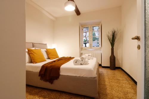 a bedroom with a bed with yellow pillows and a window at CasaViva - Elegante casa con dehors a Camogli in Camogli