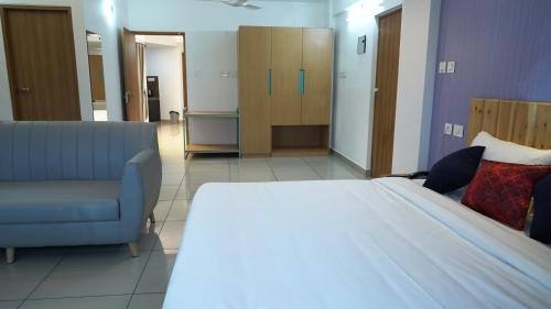 a bedroom with a bed and a couch in a room at The White Orchid Luxury Service Apartments in Ernakulam