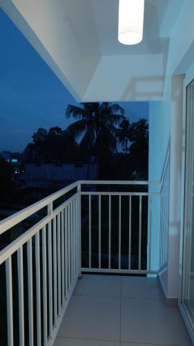 a balcony with a view of a palm tree at The White Orchid Luxury Service Apartments in Ernakulam