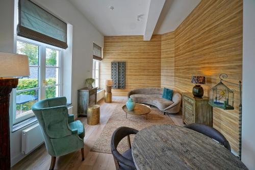 uma sala de estar com um sofá, uma mesa e cadeiras em Hotel Abdijhof Thorn em Thorn