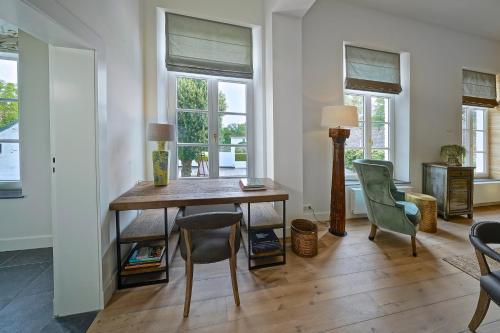 a dining room with a table and chairs and windows at Hotel Abdijhof Thorn in Thorn