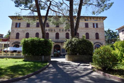 a large brick building with trees in front of it at Hotel Terme in Sarnano