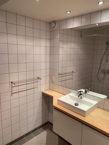 uma casa de banho com um lavatório e um espelho em Bright apartment in historic City Center em Copenhague