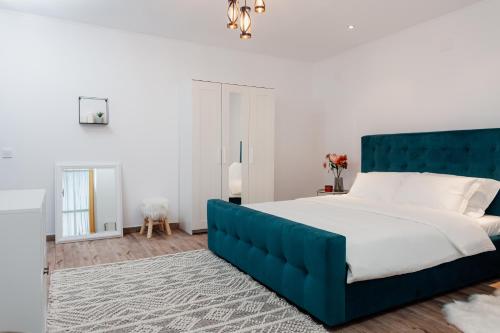 um quarto com uma cama grande e uma cabeceira azul em Scandinavia Residence em Piatra Neamţ