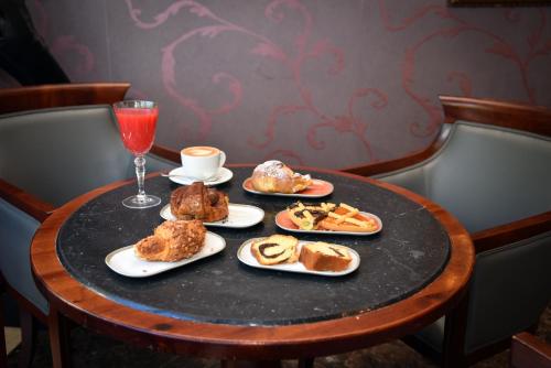 a table with plates of food and a glass of wine at Hotel Terme in Sarnano