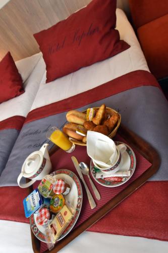 a tray of breakfast food on a bed at Saphir Grenelle in Paris