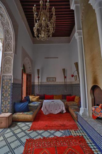 un salon avec un canapé et un lustre dans l'établissement RIAD LOUDAYA AND SPA, à Fès