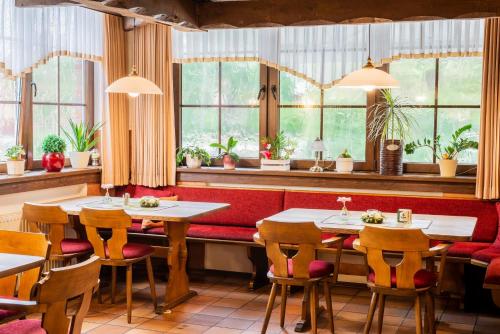 un ristorante con tavoli, sedie e finestre di Gästezimmer 2 im Landgasthaus Lindenhof a Fresenburg