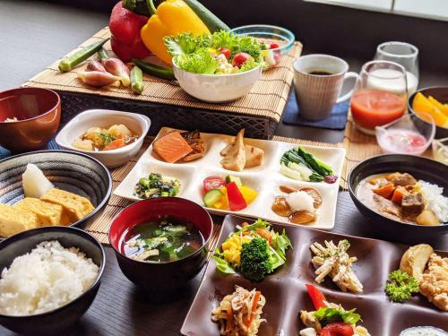 Kutsurogijuku Chiyotaki في أيزواكاماتسو: طاولة بها أطباق طعام وأوعية طعام