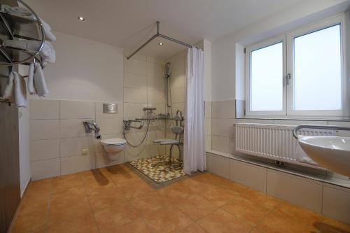 a bathroom with a sink and a toilet and a window at Neureuth in Bad Wiessee