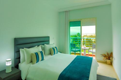 a bedroom with a large bed and a balcony at Résidence Hôtelière Riviera Beach in Cabo Negro