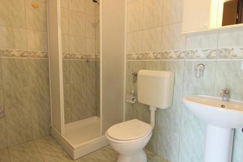 uma casa de banho com um WC, um chuveiro e um lavatório. em MONIKA A2+1 em Novigrad Istria
