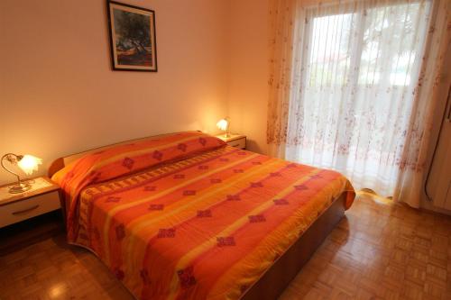 um quarto com uma cama e uma janela com cortinas em MONIKA A2+1 em Novigrad Istria