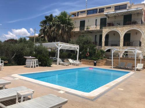 a large swimming pool in front of a building at Villa Ceni - Appartamenti con camere, cucina, wc e terrazza sul mare in villa con piscina, giardino e parcheggio in Marinella di Selinunte