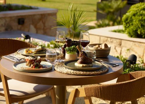a table with plates of food and glasses of wine at Asterion Suites & Spa - Designed for Adults in Gerani Chanion