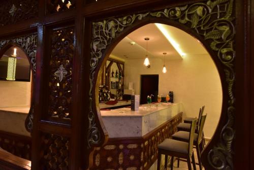 an ornate mirror in a room with a bar at Hôtel Fès Inn & SPA in Fès
