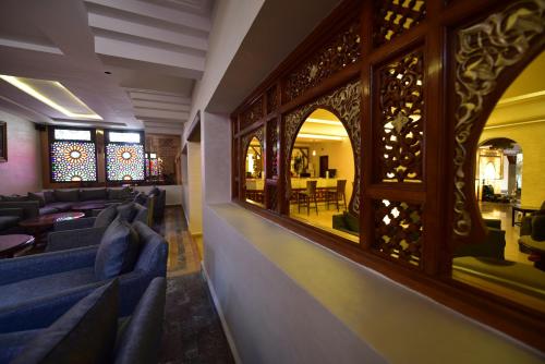 a restaurant with blue couches and a mirror at Hôtel Fès Inn & SPA in Fès