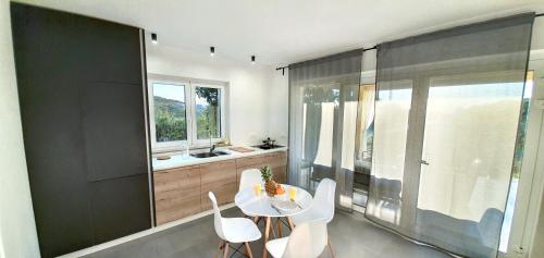 a dining room with a white table and chairs at New Apartments Škofije Ankaran in Koper