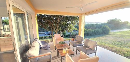 a screened in porch with a couch and chairs at New Apartments Škofije Ankaran in Koper