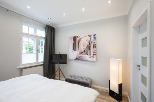 ein Schlafzimmer mit einem weißen Bett und einem Fenster in der Unterkunft Wohnperle Apartment Estelle in Dresden