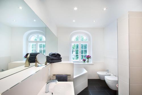 a white bathroom with a sink and a toilet at Wohnperle Apartment Estelle in Dresden