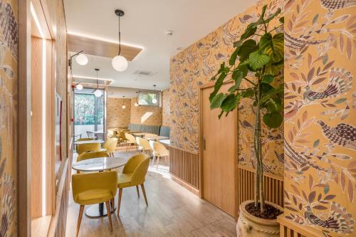 a dining room with a table and chairs and a plant at Legends House by Sweet Porto in Porto