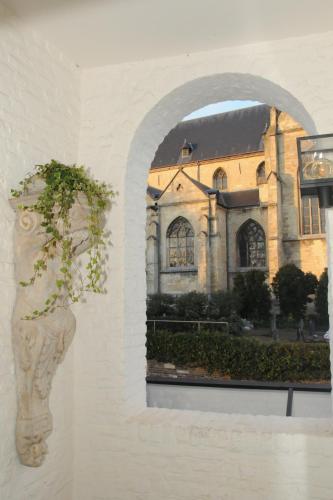 a vase with a plant in front of a building at Hotel Abdijhof Thorn in Thorn