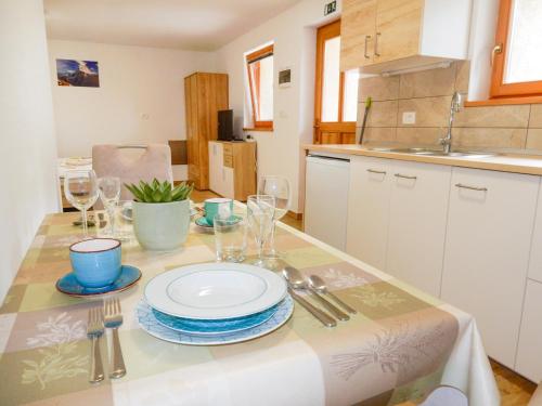 una cocina con una mesa con platos y copas de vino en Apartments and rooms Kravanja en Trenta