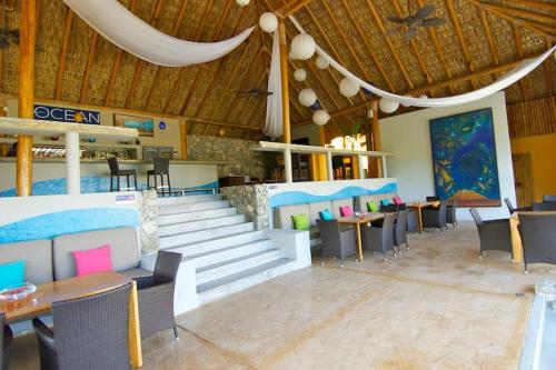 a dining room with tables and chairs and a staircase at 2055 - Cosmo 8A2 in Santa Cruz Huatulco